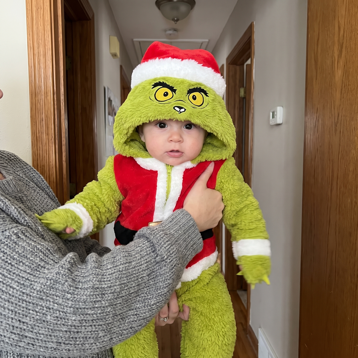 Parent holding a baby in the My Cozy Grump onesie